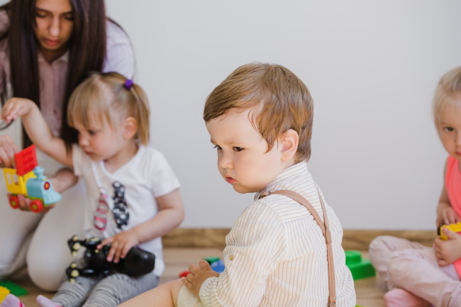 Kinder sitzen am Boden und spielen